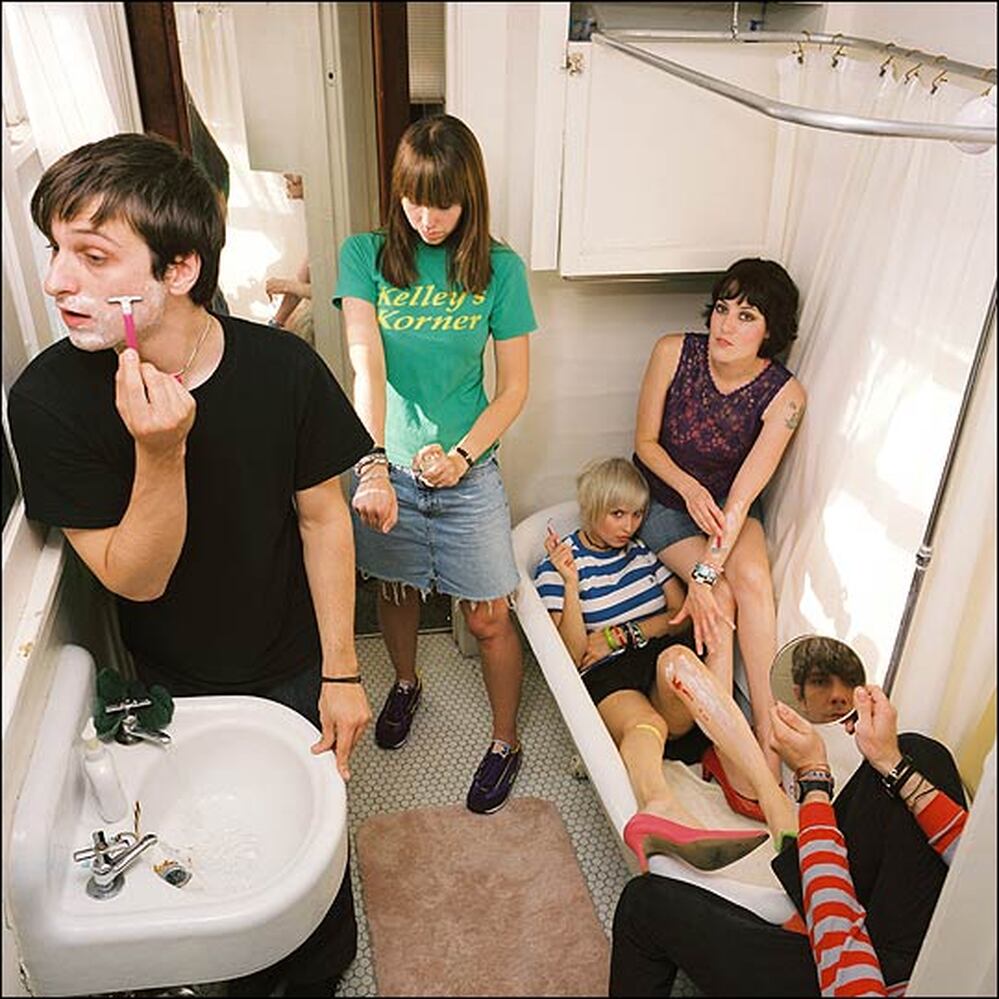 Members of Tilly and the Wall pose in a crowded bathroom for a publicity shot.