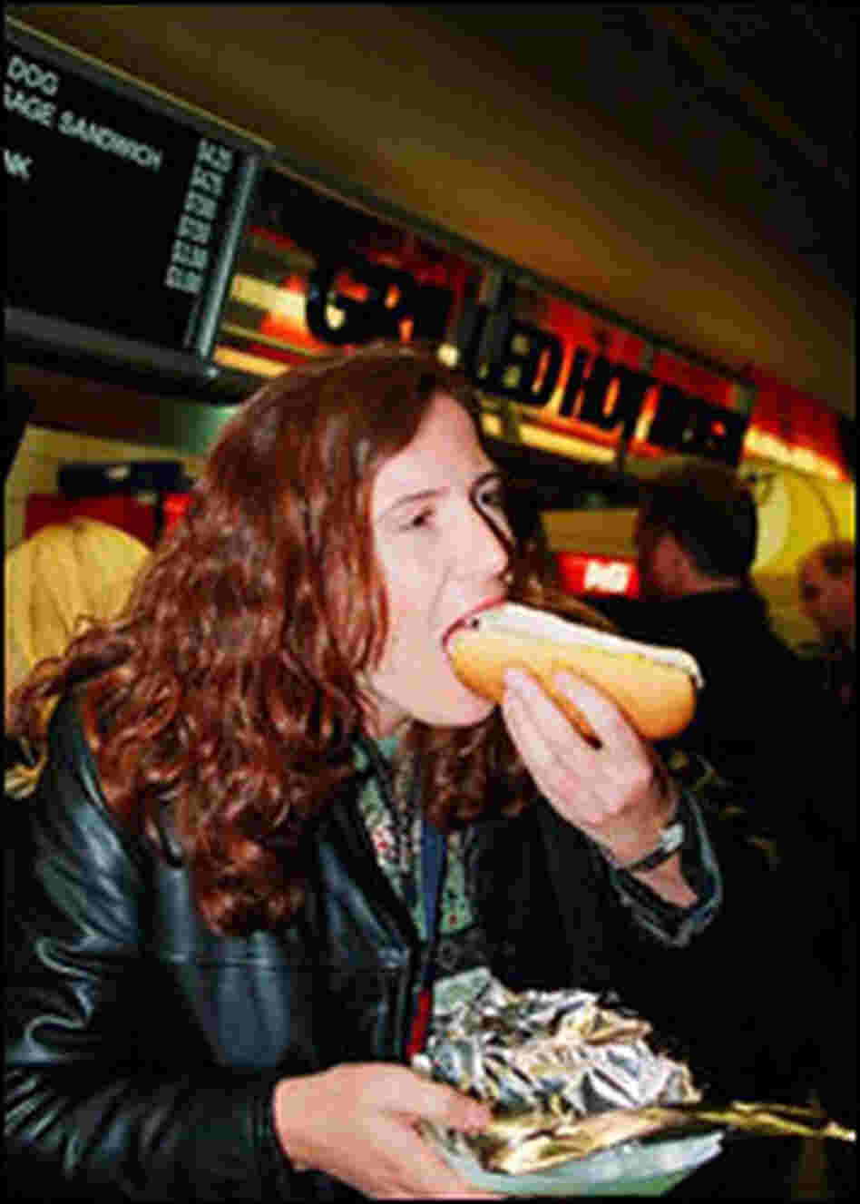 Woman eats a hot dog at Soldier Field in Chicago. Woman eats a hot dog at Soldier Field in Chicago.