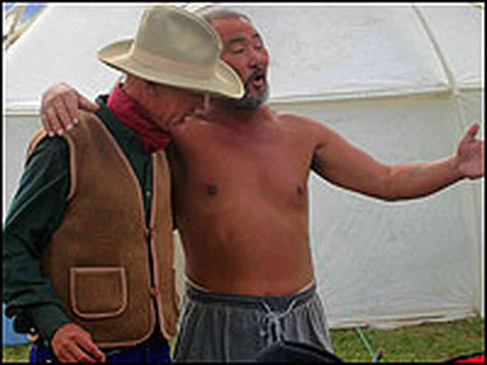Tseye, a Mongolian horse guide, sings to cowboy fiddler Ron Kane. Tseye, a Mongolian horse guide, sings to cowboy fiddler Ron Kane.