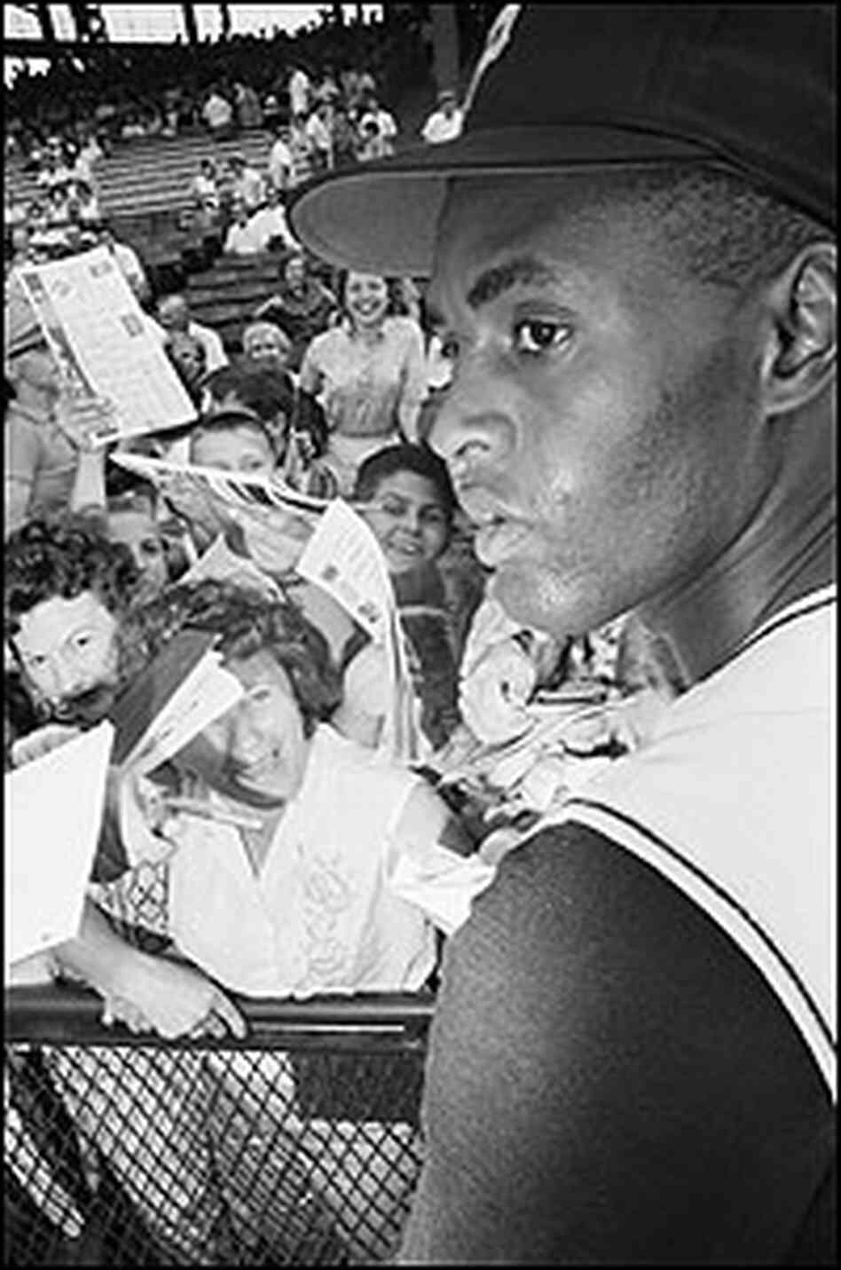 Fans seek Roberto Clemente's autograph at a 1962 game in Pittsburgh.