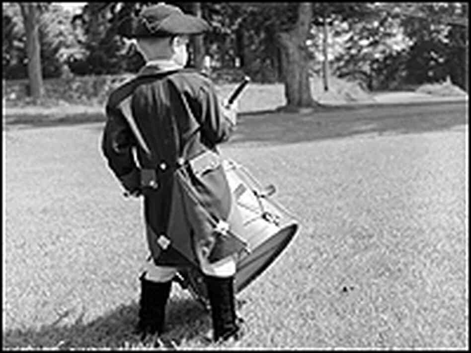 The youngest member of the Fife & Drum Corps of Chester, Conn., doing a three-beat roll on a drum.