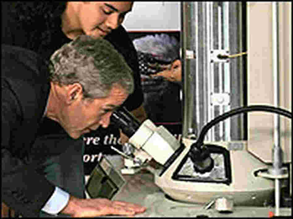 President Bush looks through an electron microscope beside student Adan Armas. President Bush looks through an electron microscope beside student Adan Armas.