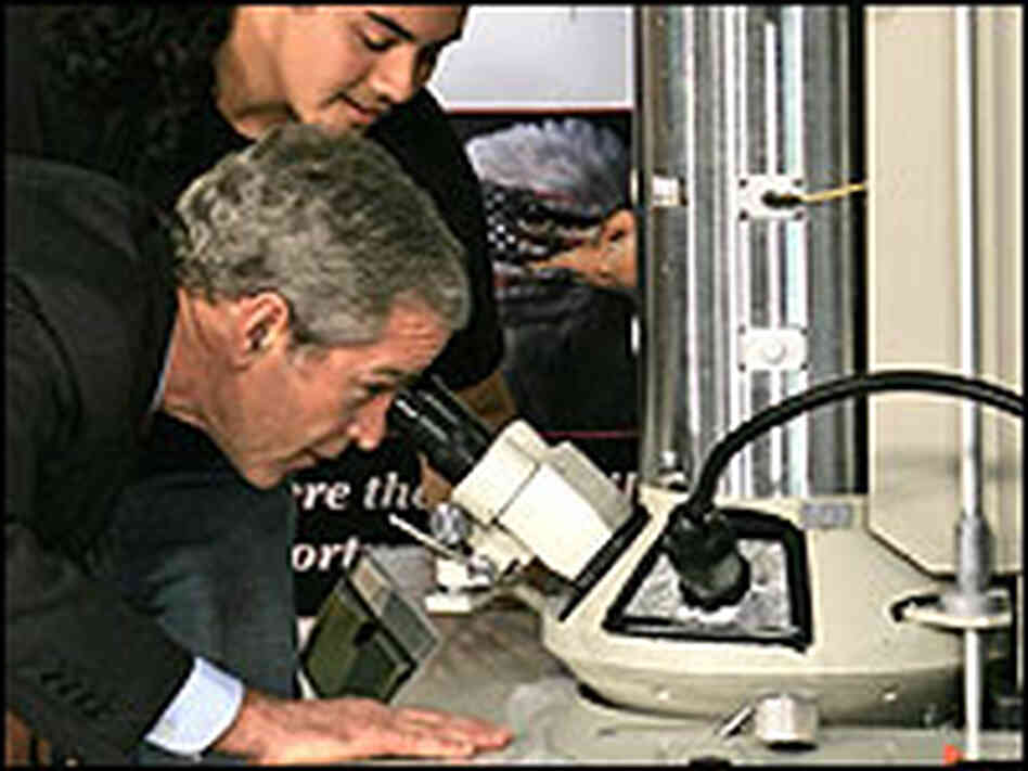 President Bush looks through an electron microscope beside student Adan Armas. President Bush looks through an electron microscope beside student Adan Armas.