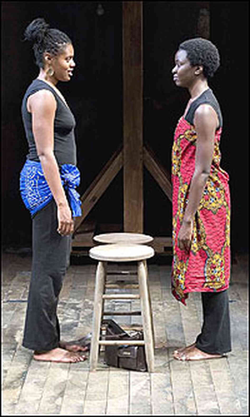 Nikkole Salter and Danai Gurira stand face to face on stage.