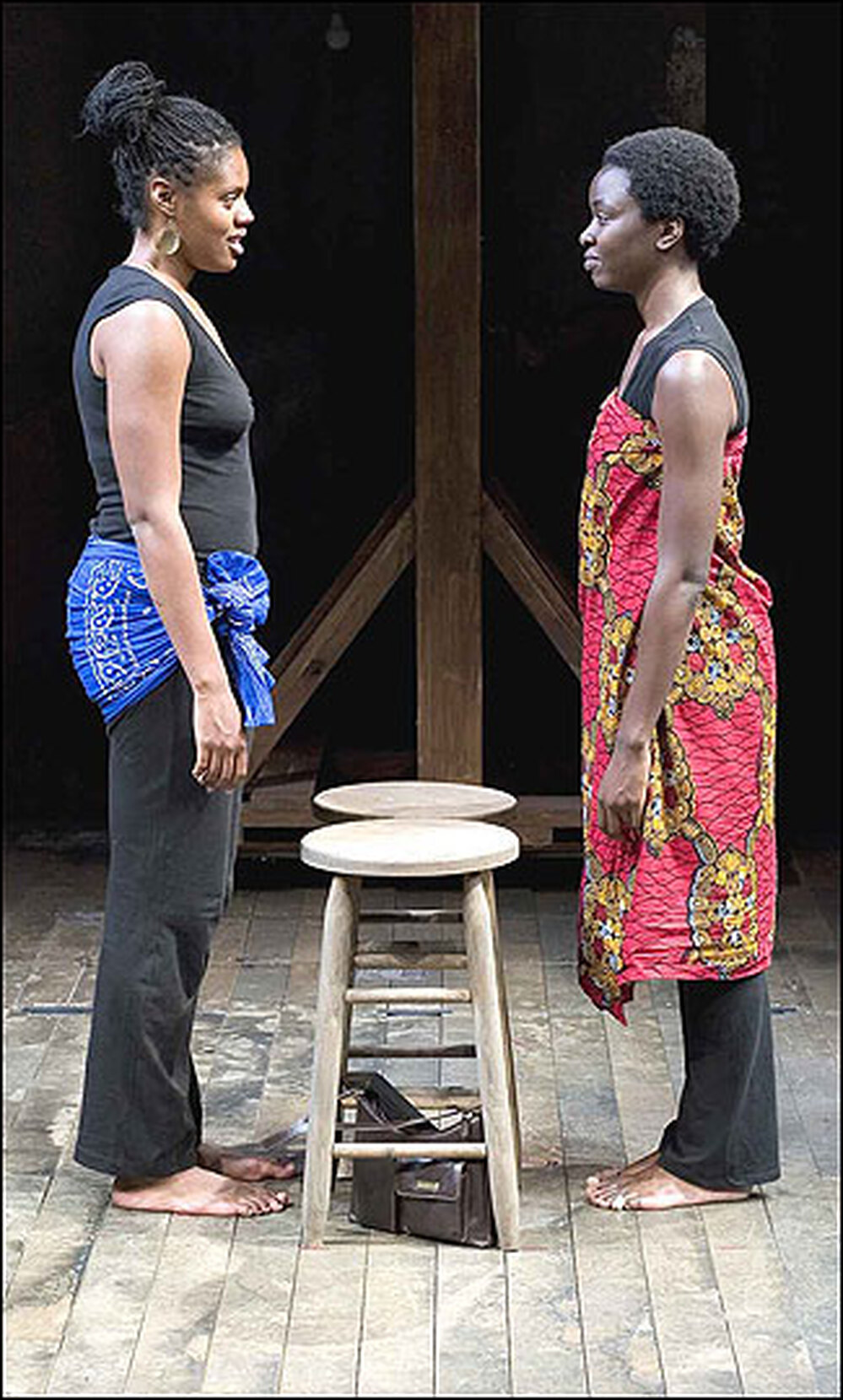 Nikkole Salter and Danai Gurira stand face to face on stage.