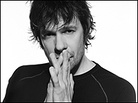 Paul Westerberg folds his hands in front of his face in a black and white PR shot. Paul Westerberg folds his hands in front of his face in a black and white PR shot.