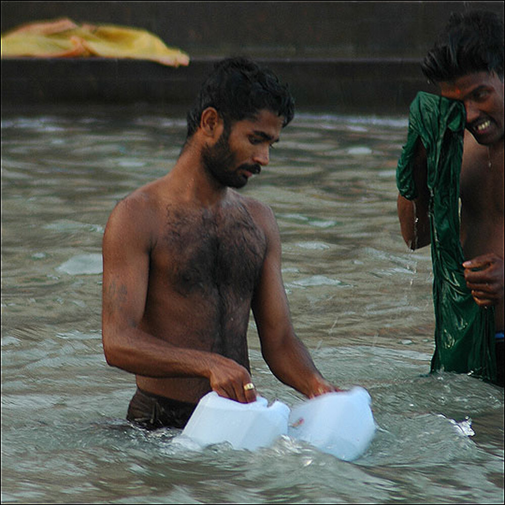 A man gathers water from the Ganges River.