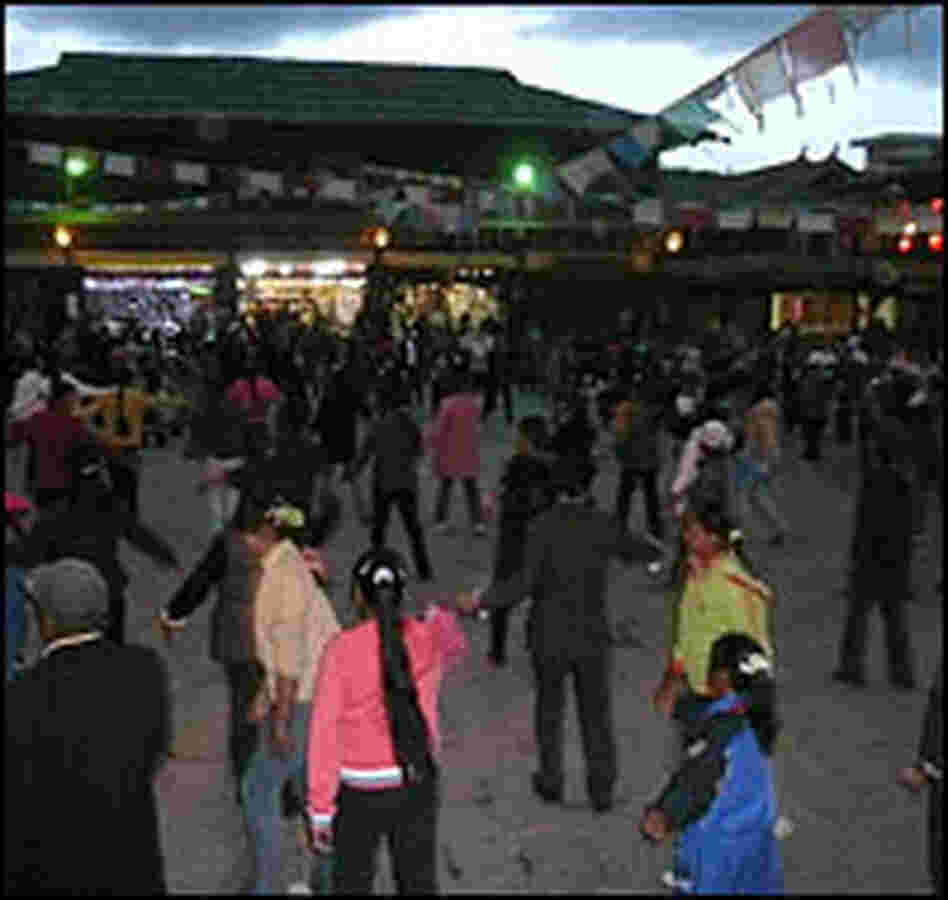 Local residents dance in the square of the old town.