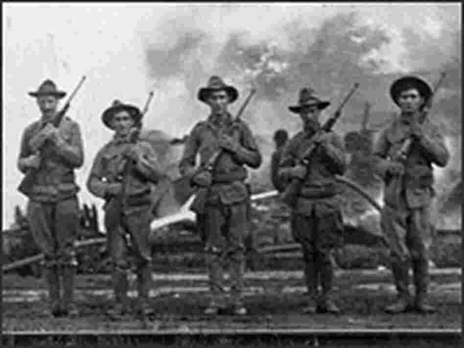 Troops guard smoldering ruins of black homes on East Madison Street.