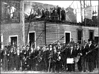 White men posed at a charred building in Wilmington, N.C.