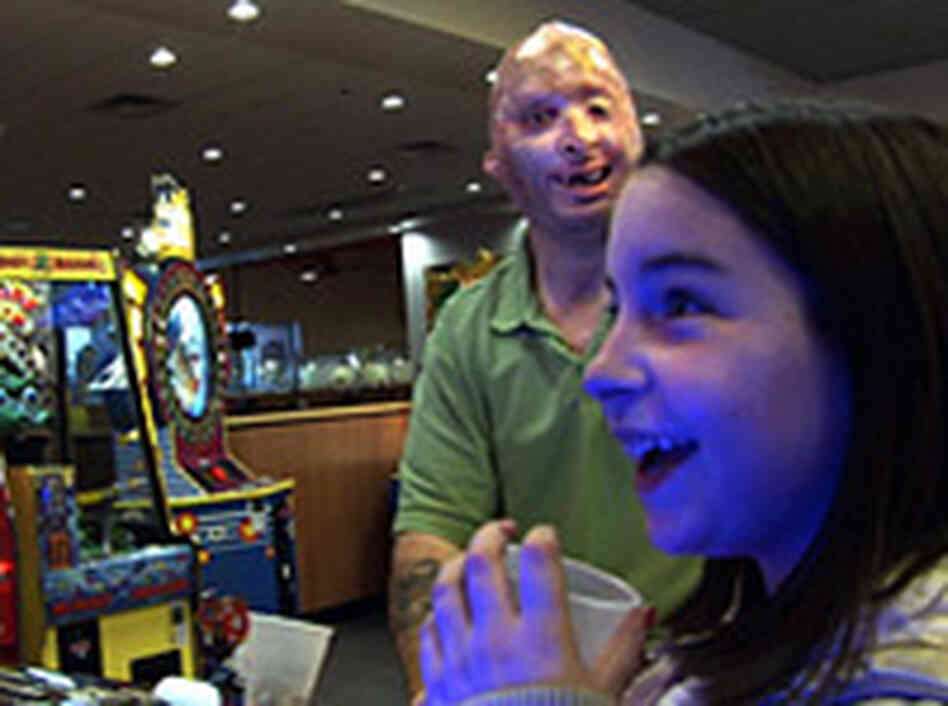 Sgt. Henline plays video games with his daughter. John Poole/NPR