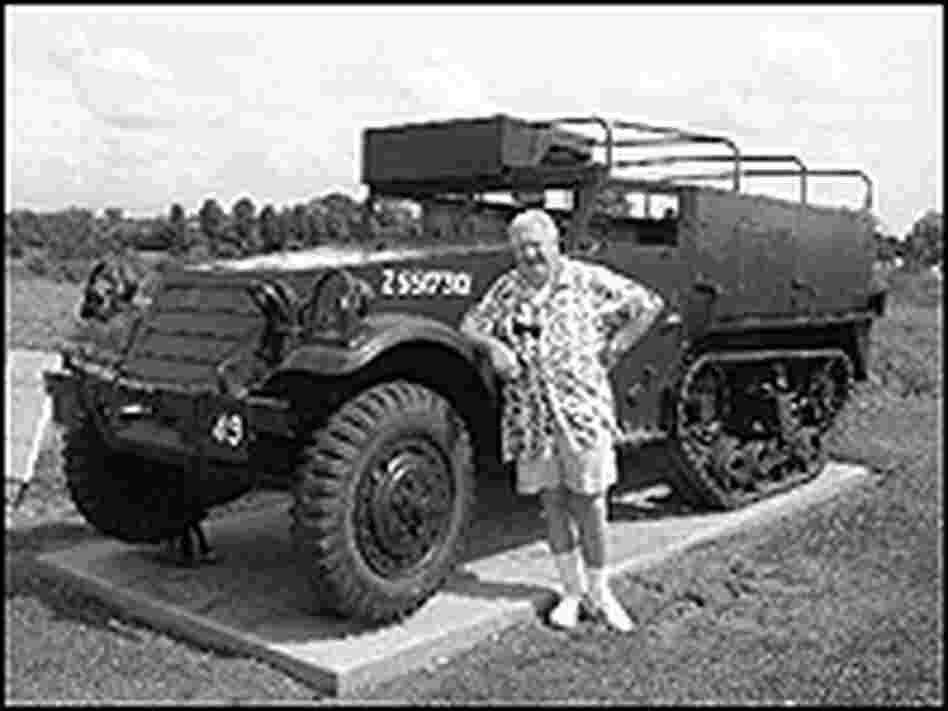 James Shiels stands next to a British half-track vehicle.