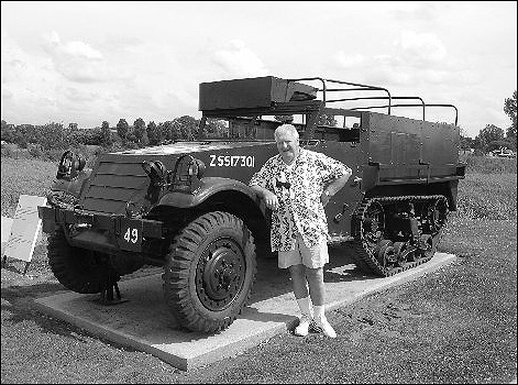 James Shiels stands next to a British half-track vehicle.