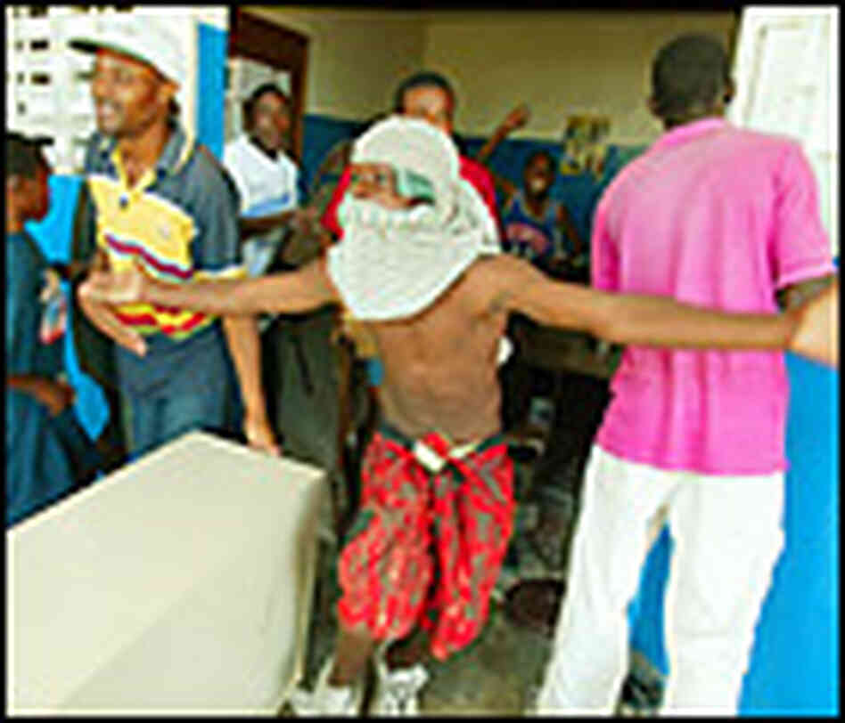 A Haitian looter gestures as people rampage through the police station in Petionville, a suburb of P A Haitian looter gestures as people rampage through the police station in Petionville, a suburb of P