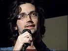 Leo Allen holds a microphone during his standup comedy act. Leo Allen holds a microphone during his standup comedy act.