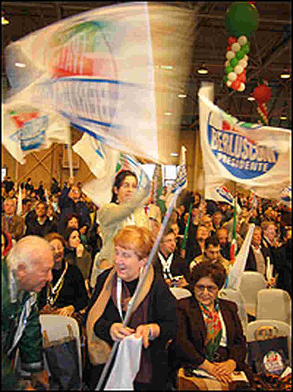A Berlusconi supporter waves a huge flag.