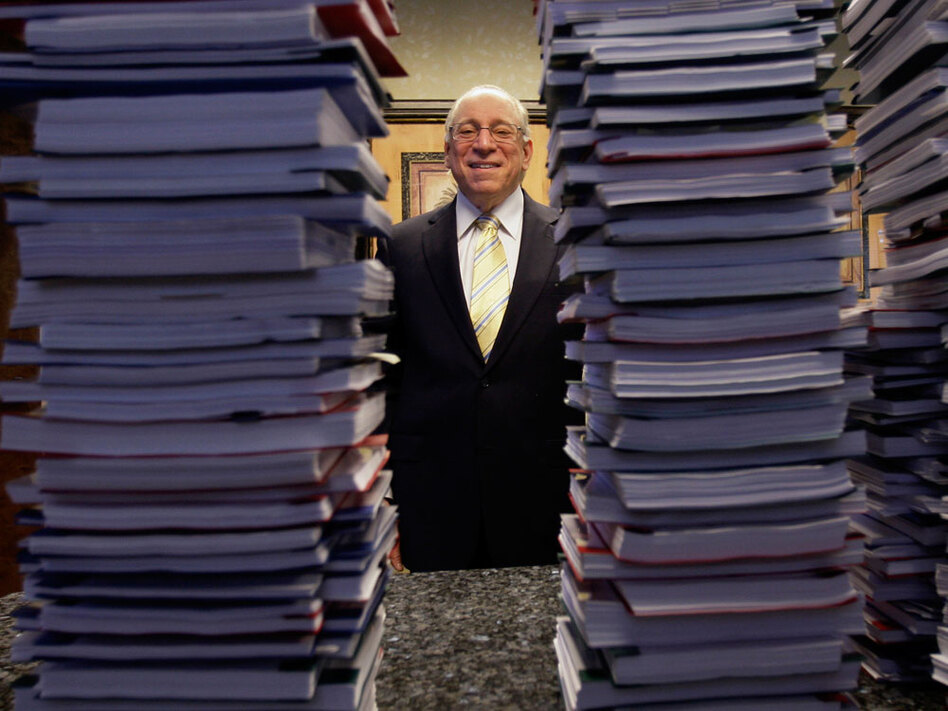 Lawyer Peter Ticktin of the Ticktin Law Group in South Florida poses behind stacks of depositions from "robo-signers" of foreclosure documents. (Lynne Sladky/AP)
