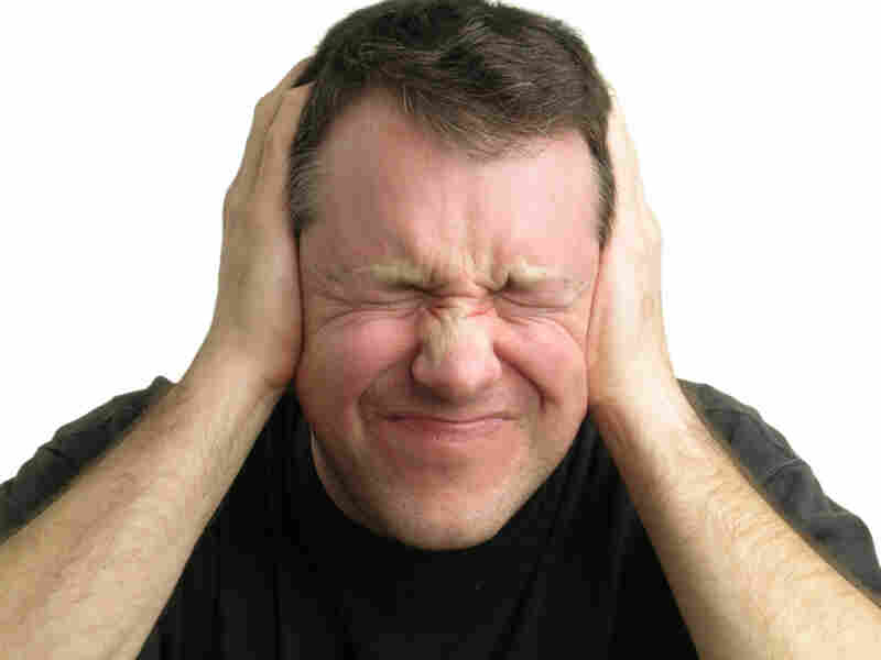 Man holding hands over ears
