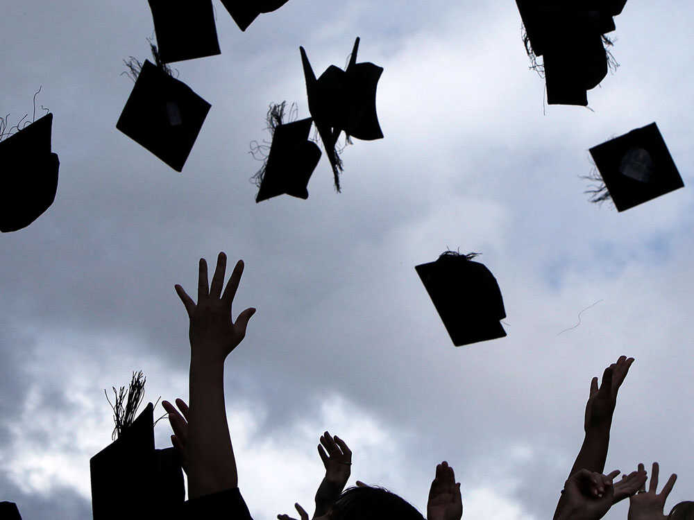 Graduates throw their caps into the air