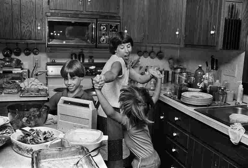 Judy and Sara stage an impromptu dance in the kitchen. Judy is just as likely to dance and sing through the grocery store. May 1986.