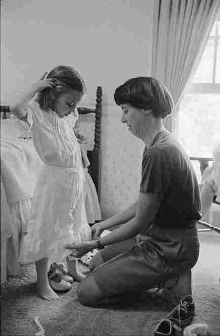 Judy McGarvey dresses Sara for her fourth birthday party, which featured a Cinderella theme including a neighbor playing the fairy godmother. May 1987.