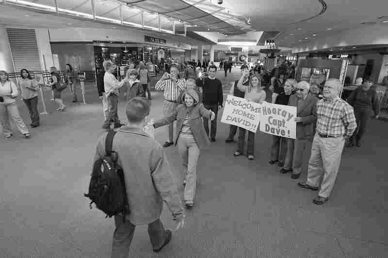 The family welcomes David home from a tour in Iraq. John McGarvey (right), who rarely shows emotion, held back tears when the crowd at the airport broke into applause. November 2006.
