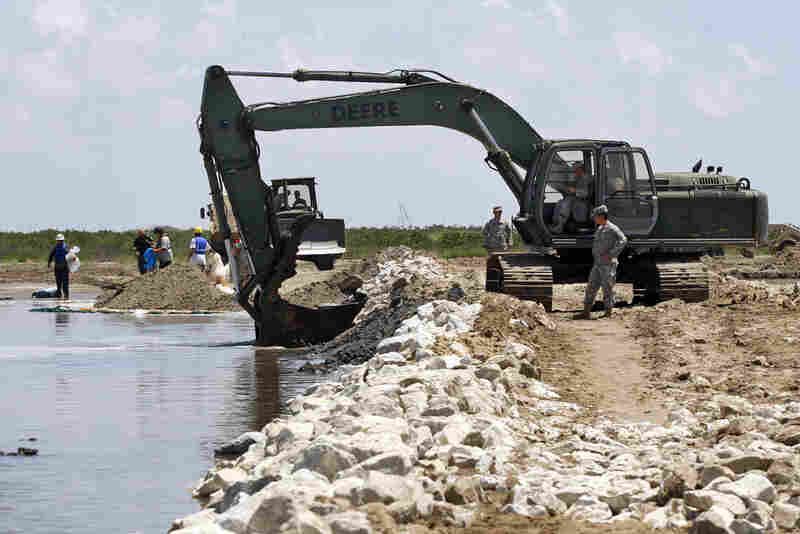 Members of the Louisiana National Guard build a land bridge at the mouth of wetlands on Elmer's Island. 