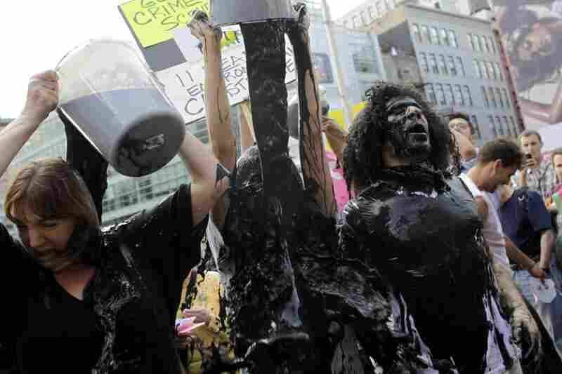 Protesters cover themselves with a water and paint mixture during a demonstration at a BP gas station in New York City on May 28. 