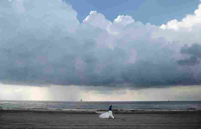 A worker leaves the beach in Grand Isle, La., on May 30. BP is turning to yet another mix of undersea robot maneuvers to help keep more crude oil from flowing into the Gulf. 