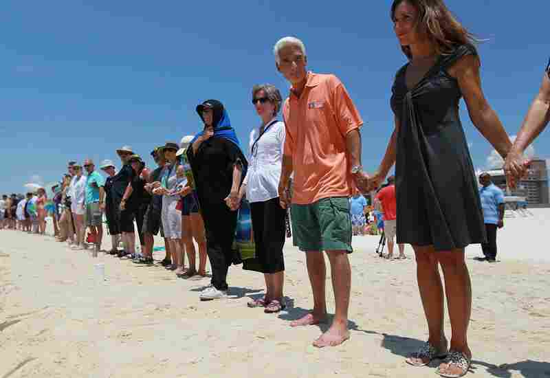 Florida Gov. Charlie Crist and wife Carole Rome Crist (right) stand with others during a Hands Across the Sand event June 26 in Pensacola, Fla. The event was staged across the nation to protest offshore oil drilling. 