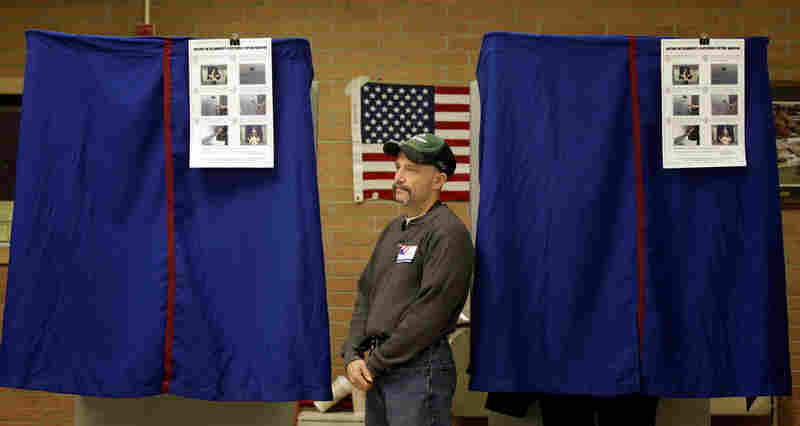 An election worker monitors a voting booth in Wilmington, Del. Democrat Chris Coons defeated Christine O'Donnell in the Senate runoff. 