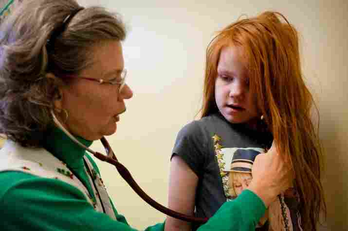Nurse practitioner Barbara Moore examines Katie. Last year, Katie's lead levels were so high that she had to be treated with chelation.