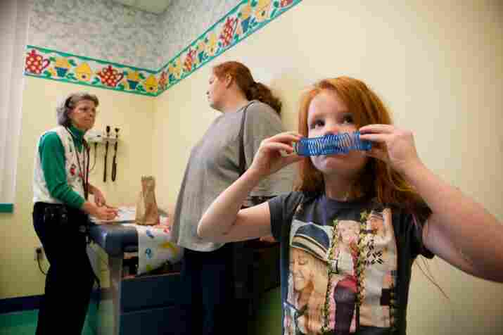 Katie watches TV in the exam room while Oliver talks with Moore about the possibility of Katie needing another round of chelation.
