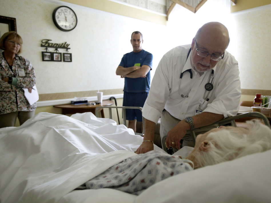 Dr. Joel Policzer checks on Lillian Landry, a patient in the hospice wing of a Florida hospital. Landry made end-of-life decisions to receive little care. (J Pat Carter/AP)