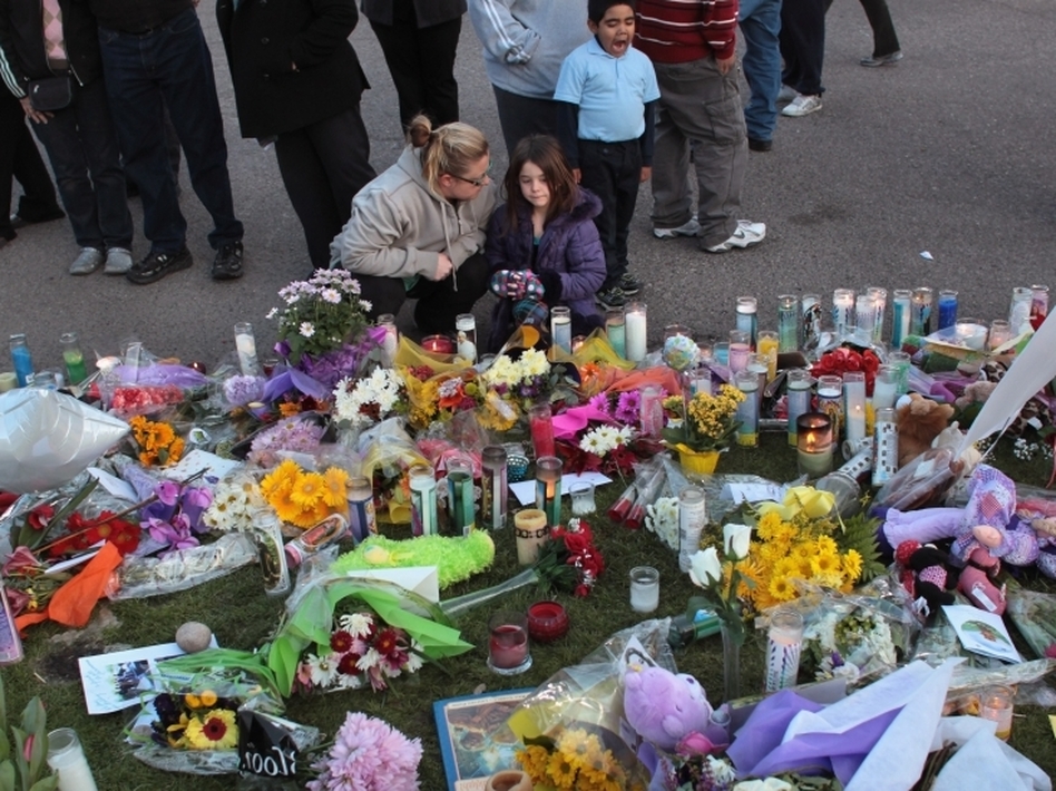 Mourners visit a memorial shrine to victims of this weekend's shooting rampage in Tuscon, Arizona. Some have called for a reconsideration of political rhetoric in the wake of the tragedy. (John Moore/Getty Images)
