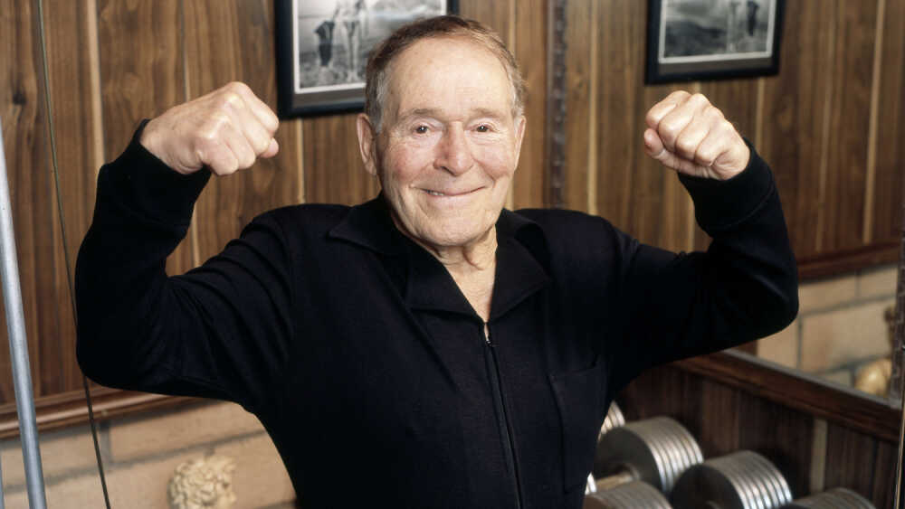 Enthusiastic Man smiling big, arms stretched out in front, palms