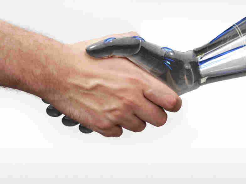 A human and robot shake hands