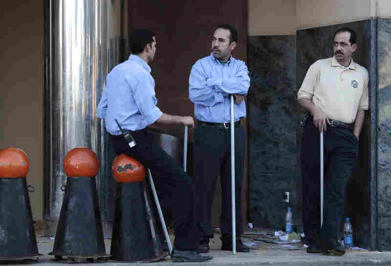 Egyptian men hold poles to ward off looters near a shopping center  in Cairo on Sunday. 