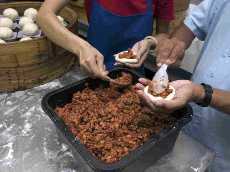 Workers at Shay Shay Tien make pow, placing the meat filling onto discs of dough that will go in a steamer basket