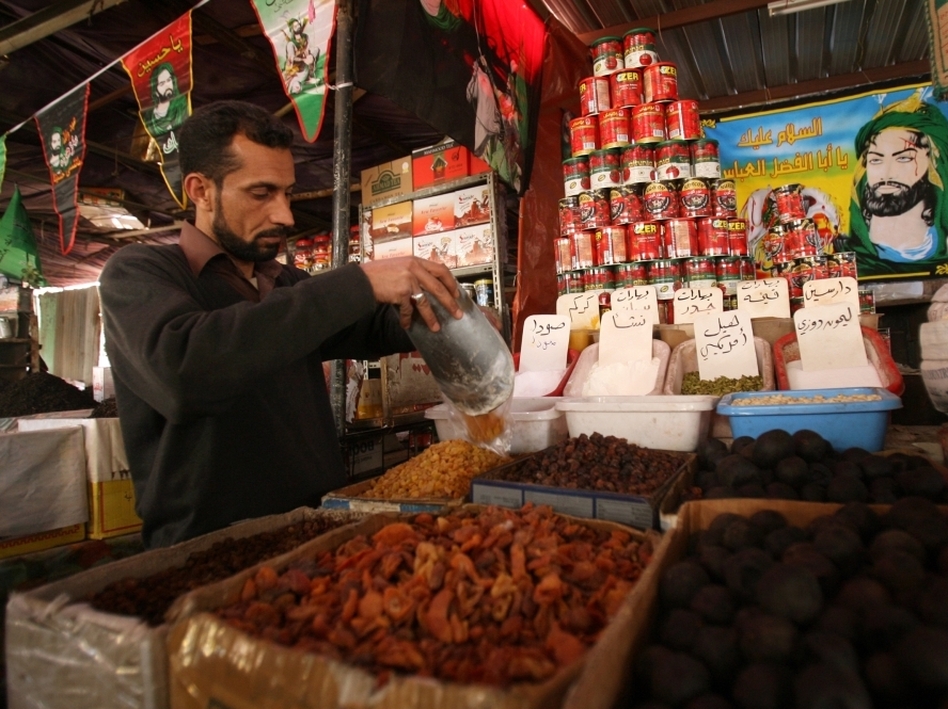 An Iraqi shop owner sells groceries in Baghdad. World Bank President Robert Zoellick says the high cost of food is an "aggravating factor" behind the unrest in the Middle East. (Ali al-Saadi/AFP/Getty Images)