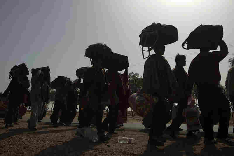Thousands of Bangladeshi refugees who fled Libya stand in a miles-long line as they walk to a refugee camp in Tunisia on Friday.  