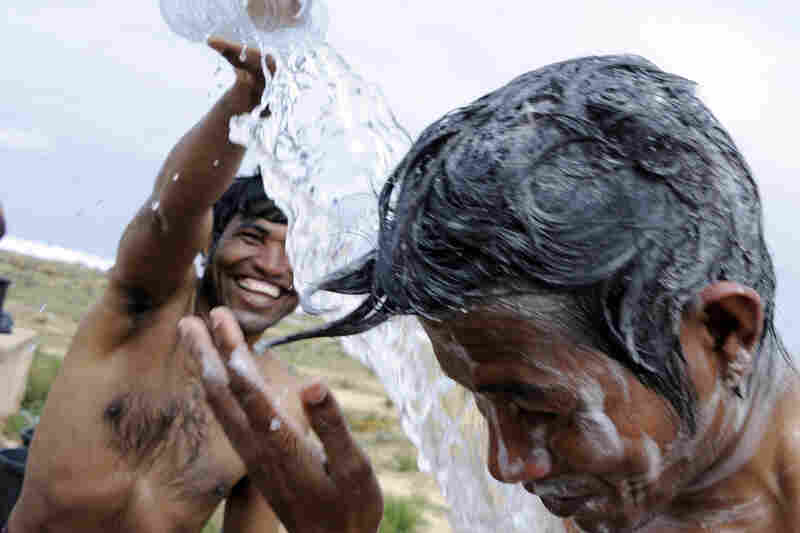 Refugees who fled Libya bathe in the Choucha refugee camp, near the Tunisian border town of Ras Jdir on Tuesday. The Red Cross and the United Arab Emirates plan to build two new camps on Tunisia's border. An estimated 100,000 mainly foreign migrants have crossed from Libya into Tunisia since Feb. 20, Tunisian officials said. 