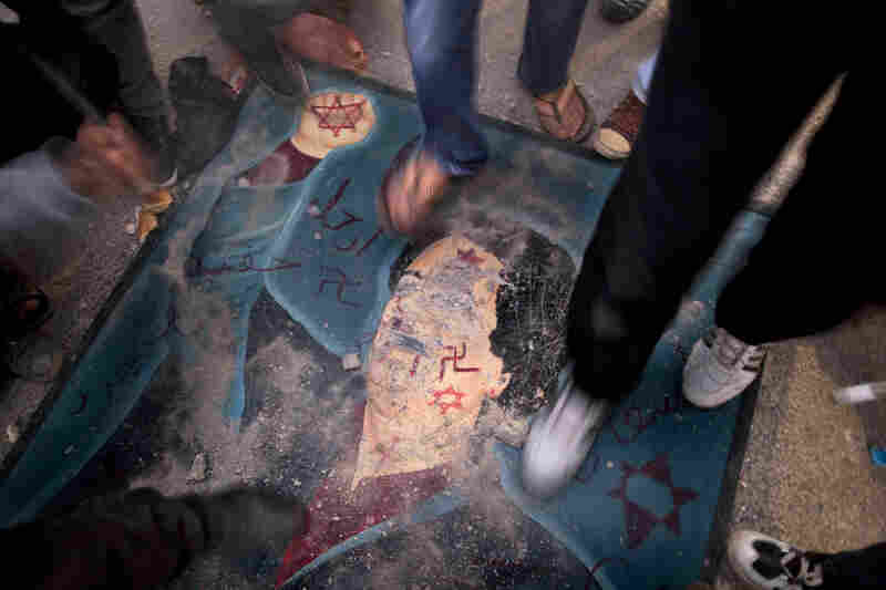 Libyans stomp on a defaced billboard of Gadhafi during a demonstration against his regime in the city of Tobruk on Saturday. 