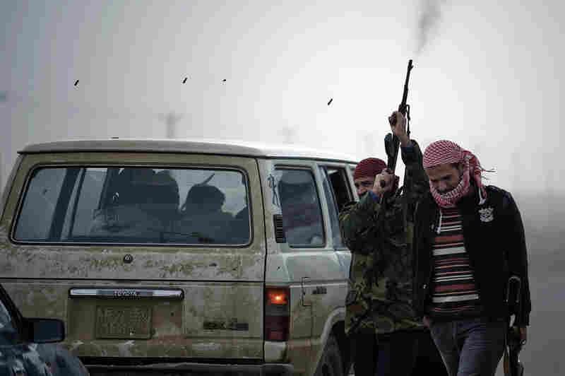 A Libyan rebel fighter fires his rifle in the air at Ajdabiya's west gate on Friday. 