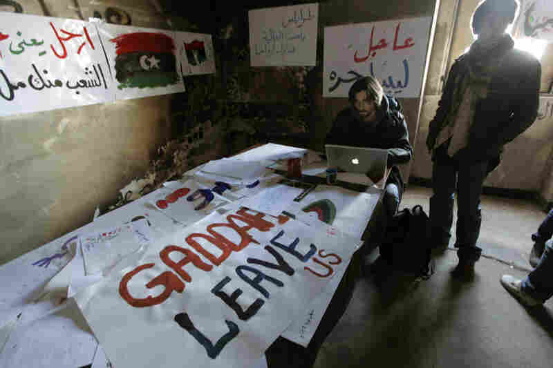Volunteers work on anti-Gadhafi banners at the newly set-up media center in Benghazi, Libya, on Monday. Libyan activists provide technical support and documents to journalists. 