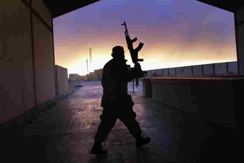 A Libyan border guard walks through an empty customs hall on the Libya-Egypt border on Thursday. 