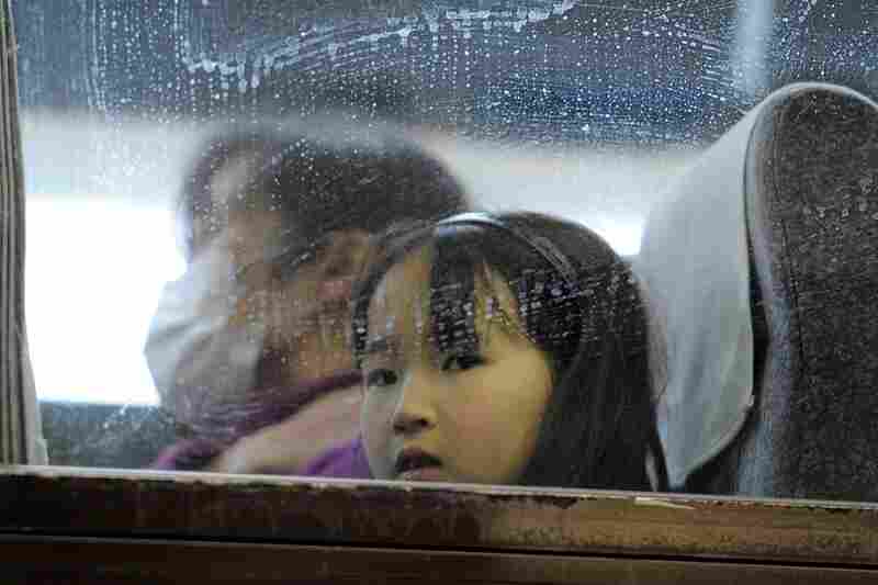 A young girl looks out from a bus window as people rush to get out of the city in Yamagata northern Japan on Tuesday. 