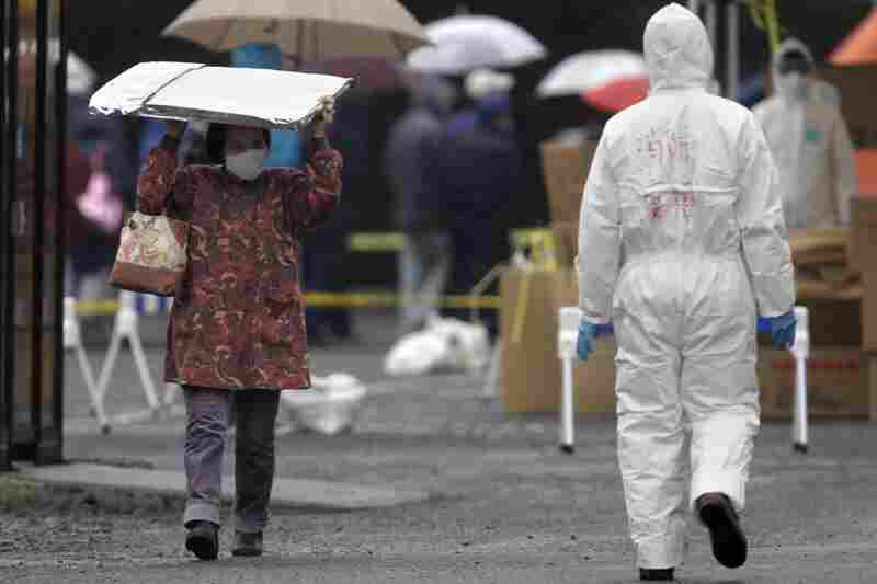 A woman carrying a heat blanket leaves a radiation emergency scanning center in Koriyama in Japan. 