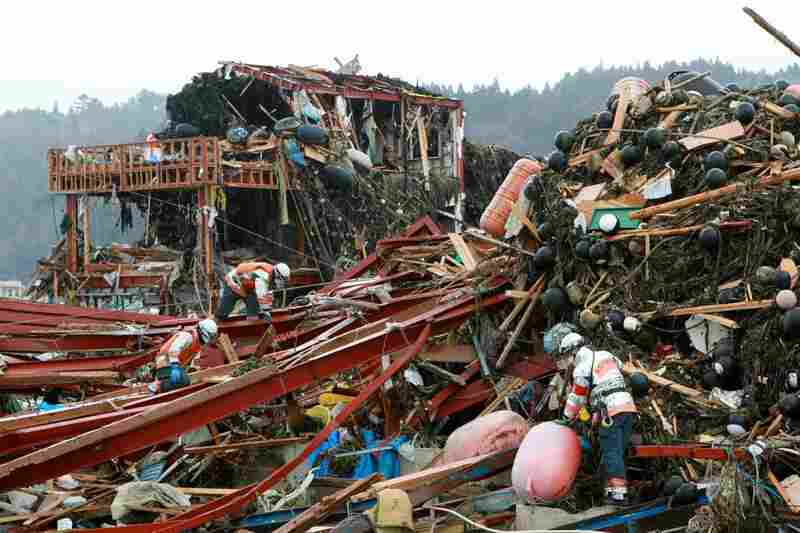 Rescue workers search for missing people at Minamisanriku town in Miyagi prefecture. 