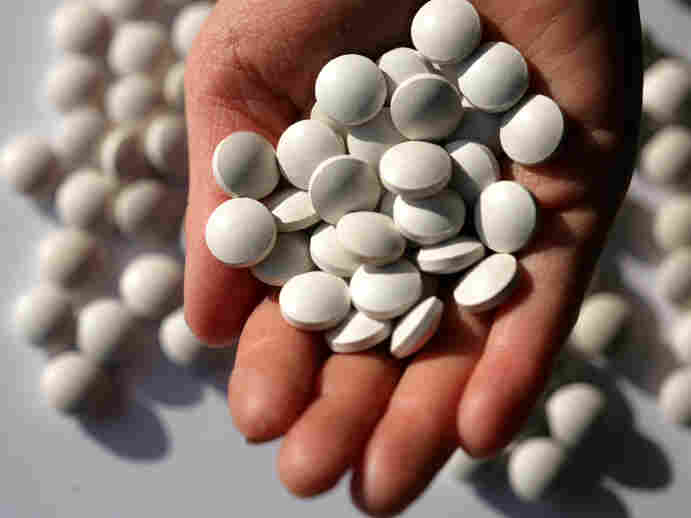 Pills in the palm of a woman's hand.